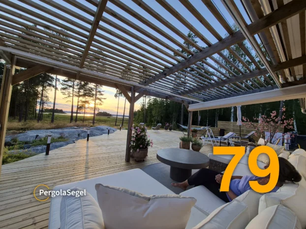 Träpergola med pergolasegel som ramar in uteplats med sjöutsikt