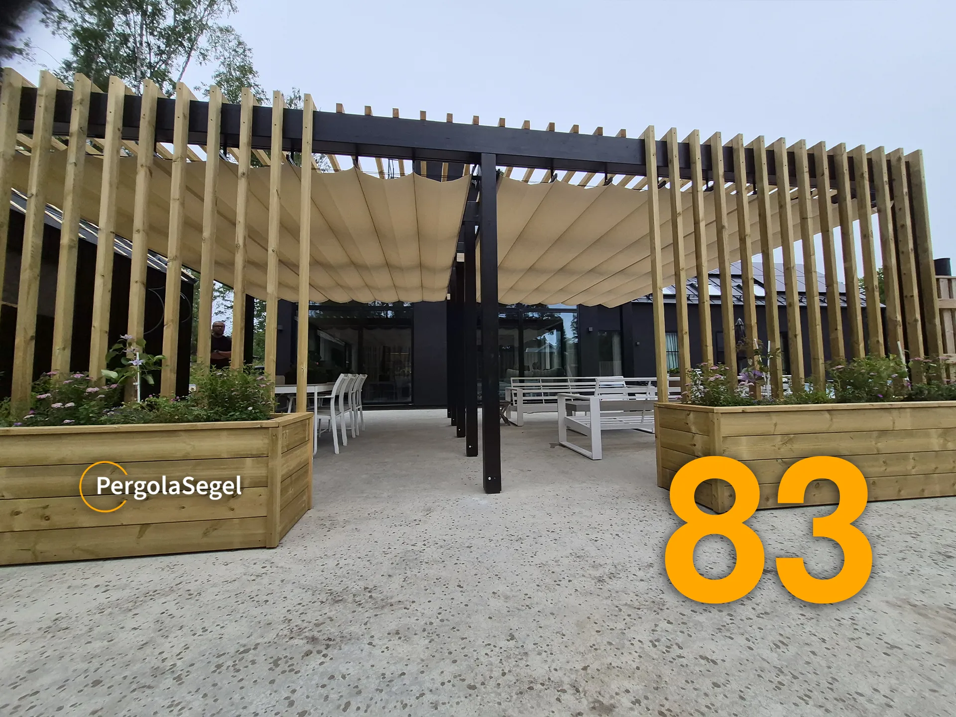 Pergola sedd framifrån med två beige segeltak, träspaljéer och planteringslådor