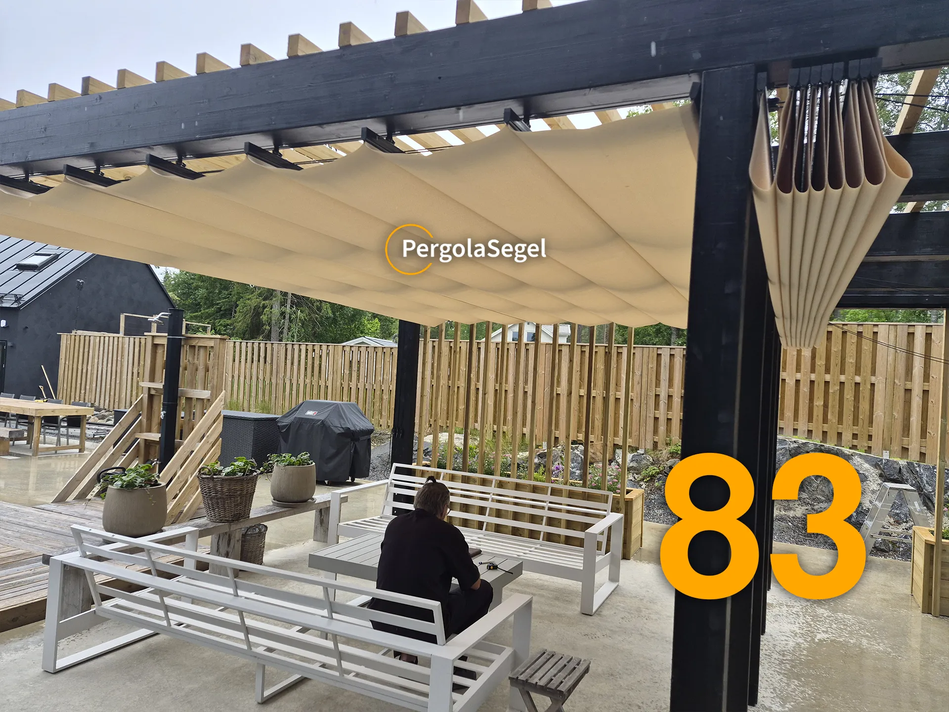 Pergola sedd från sidan med beige segel delvis indragna och synliga takribbor