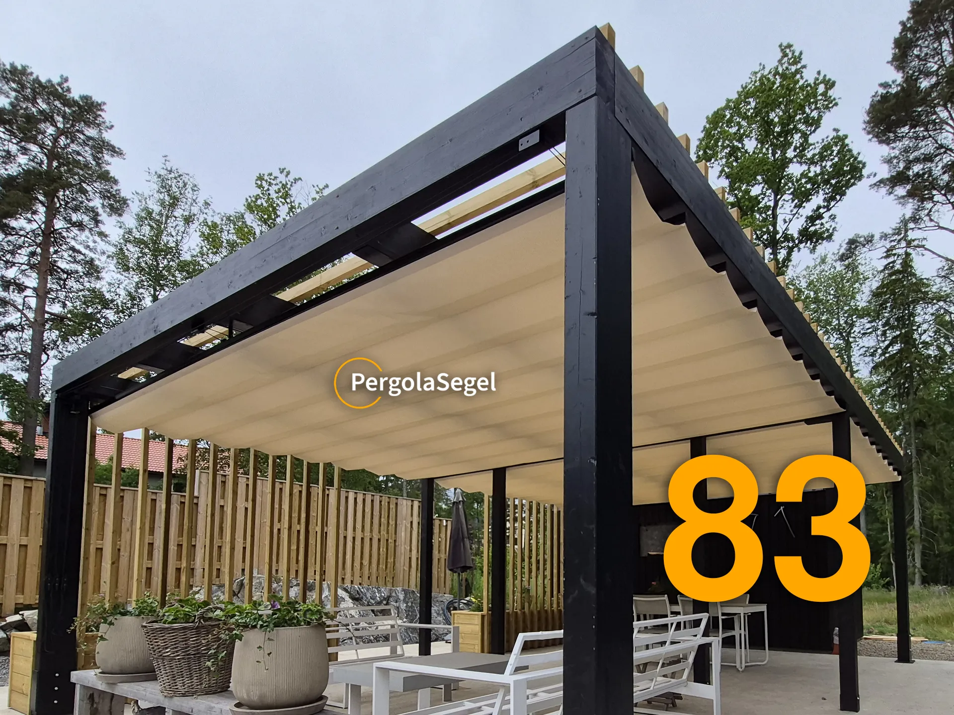 Svart pergola i limträ med beige segeltak över uteplatsens loungemöbler och matplats