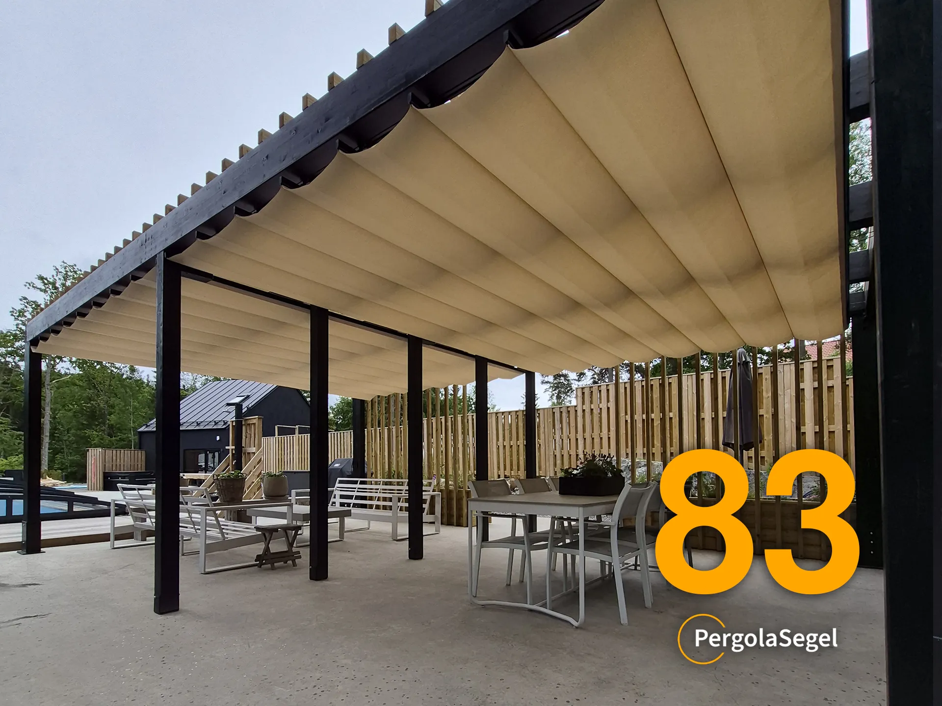 Svart pergola med beige Ferrari W95 duk och träspaljé längs matplatsen